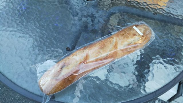 パン屋のベーカリー・デッセム店舗前のテーブルにフランスパンを置いた写真