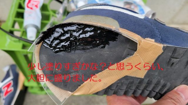 プラスチック板を固定した右足スニーカーの「かかと部分」に、シューグー黒色を塗っている写真。