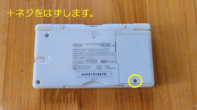 DSライトを裏側のバッテリーケースを固定している＋ネジの位置を説明した写真。