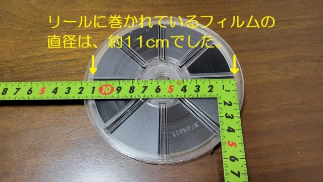 リールに巻かれている8mmフィルムの直径を、定規で計測している写真。