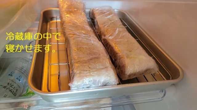 ピチット脱水シート（レギュラー）で包んだ豚バラ肉をバットに乗せて、冷蔵庫に入れた写真。